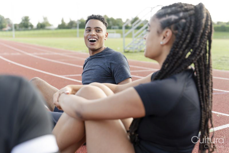 Couple of athletes resting at sports track after training