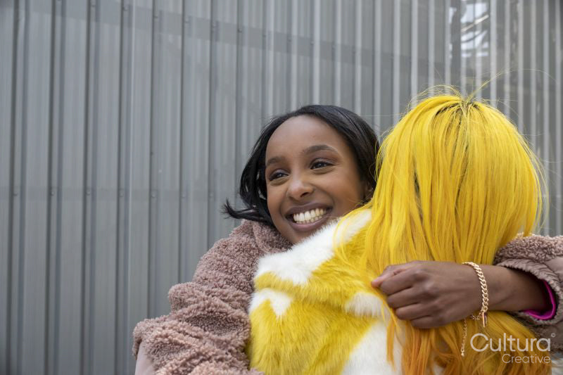 Smiling young friends hugging outdoors