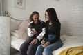 Two friends using smart phone on bed at home