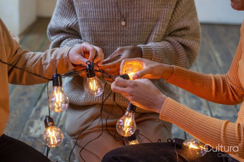 Friends untangling string light, close up