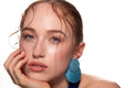 Studio portrait of a woman in a blue dress and large blue earrings