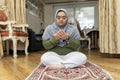 Muslim woman with down syndrome praying at home