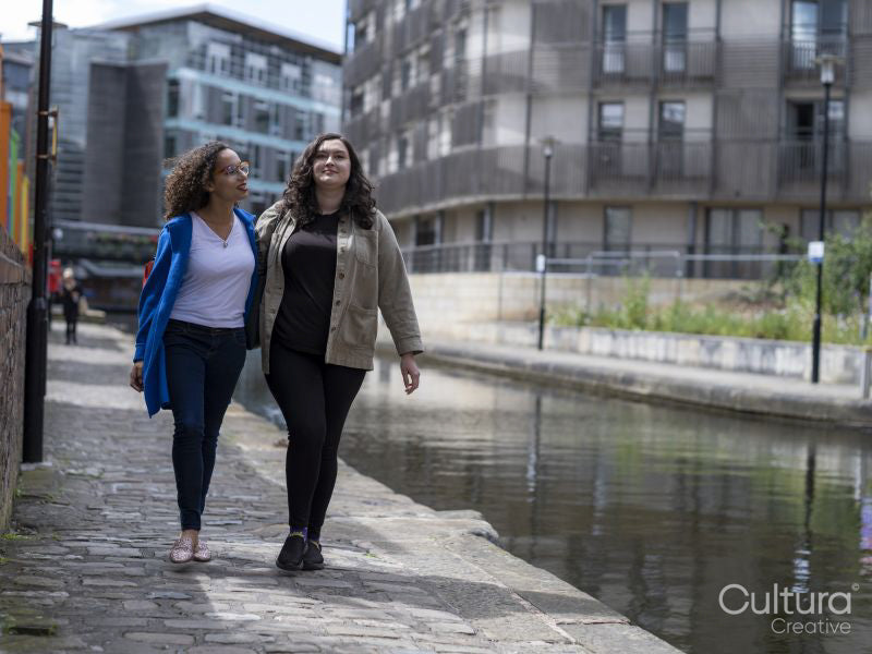 Couple walking on riverbank arm in arm