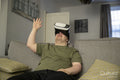 Man sitting on sofa and using VR headset
