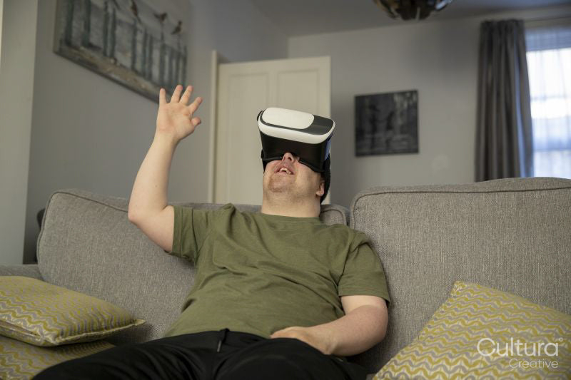 Man sitting on sofa and using VR headset
