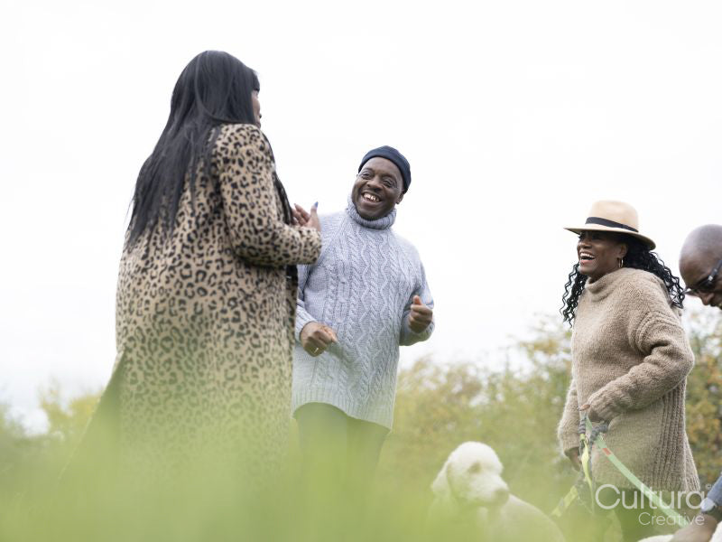 Senior couples standing with dogs and laughing in nature