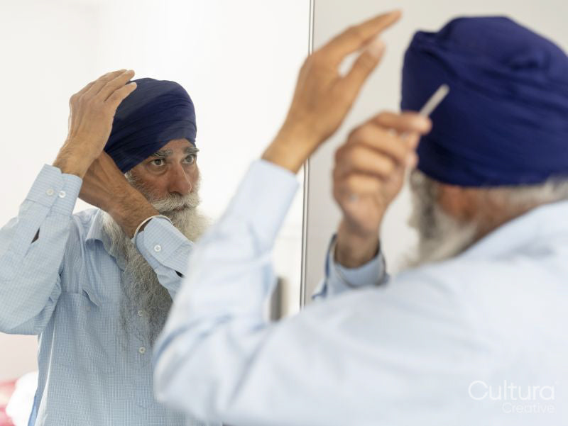 Senior man wrapping turban around head