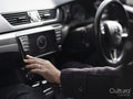 Woman using dashboard buttons in car