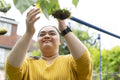 Young woman with down syndrome touching flower in garden