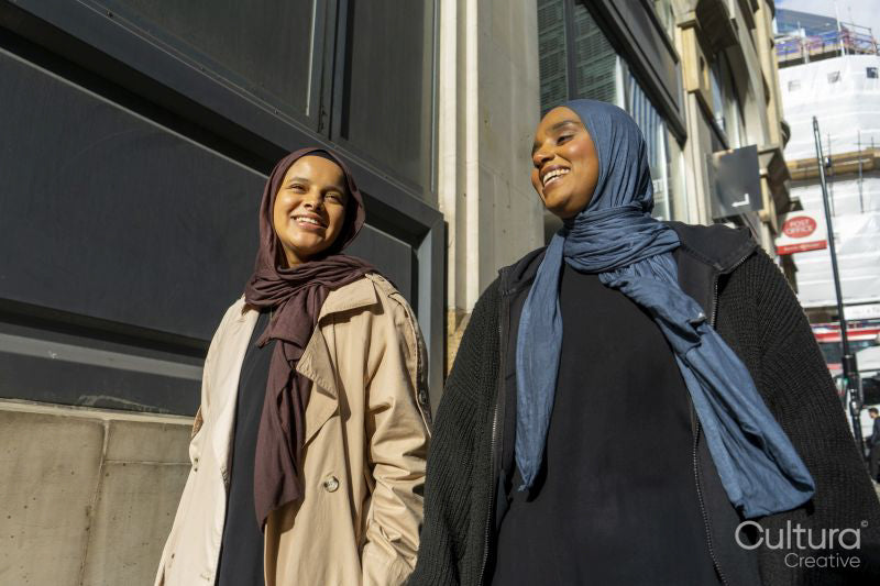 Two young women walking in street