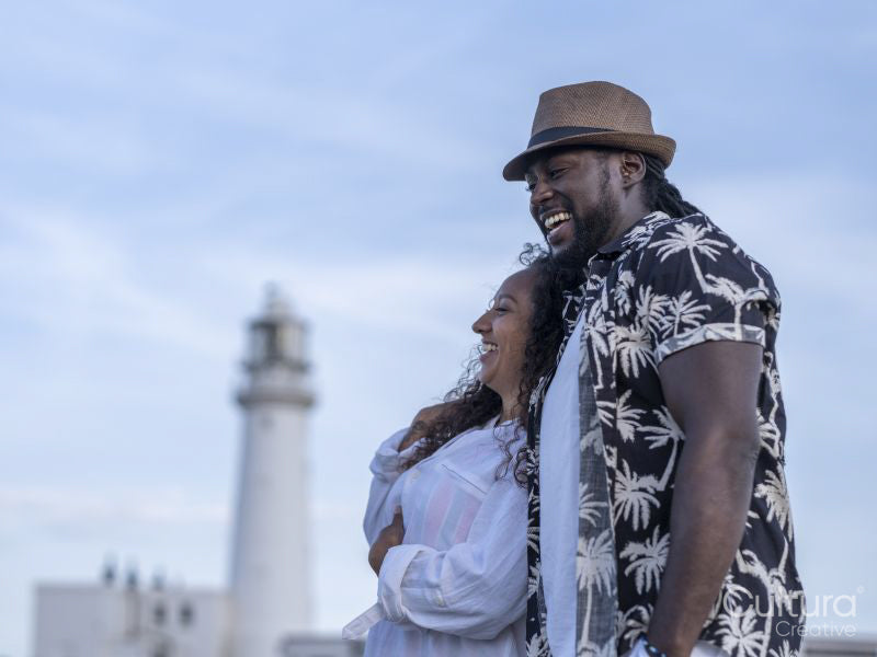 Smiling couple embracing by lighthouse