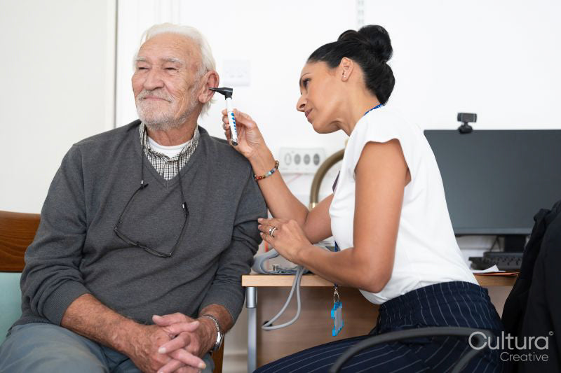 Female doctor examining patient with otoscope
