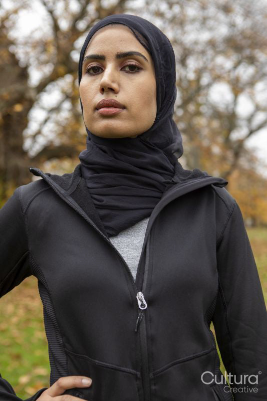 Portrait of woman in black sports clothing and hijab in park
