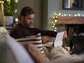 Man relaxing on sofa with digital tablet
