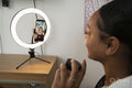 Girl holding moisturizer while filming beauty video