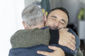 Male couple hugging at home