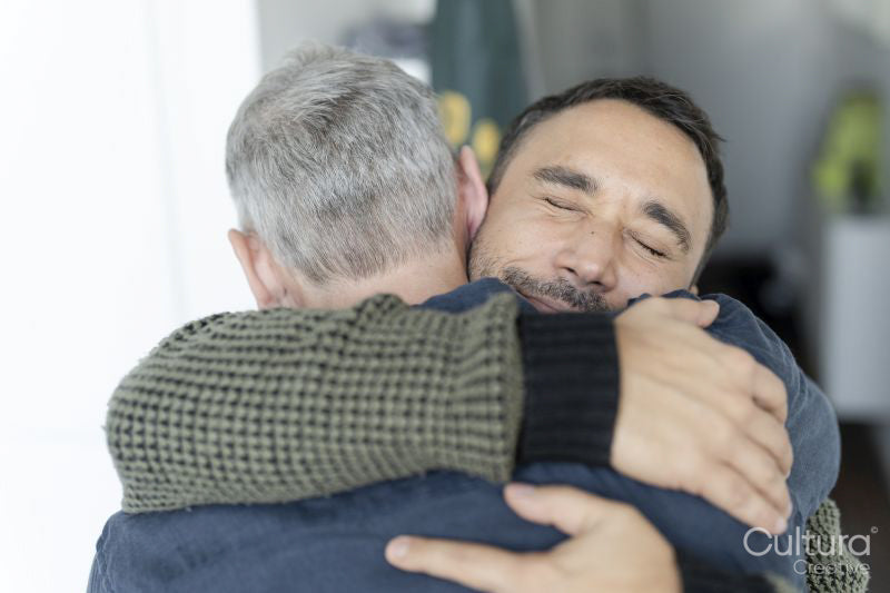 Male couple hugging at home