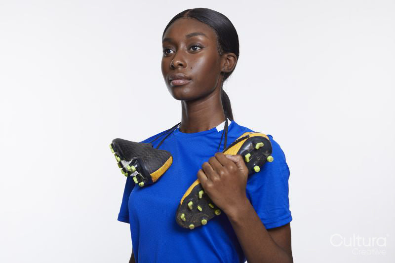 Studio portrait of woman with soccer shoes