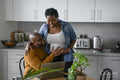 Smiling man touching pregnant woman's belly in kitchen