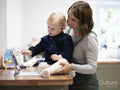 Mother standing by daughter drawing on digital tablet
