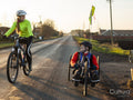 Woman riding bike and disabled man riding handcycle on country road
