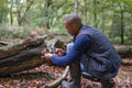 Man taking a photo of mushroom growing on log in forest at autumn