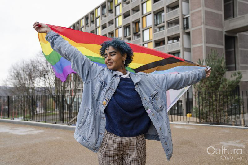 Young woman holding progress pride flag