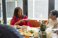 Smiling woman with mother holding Christmas cracker at table