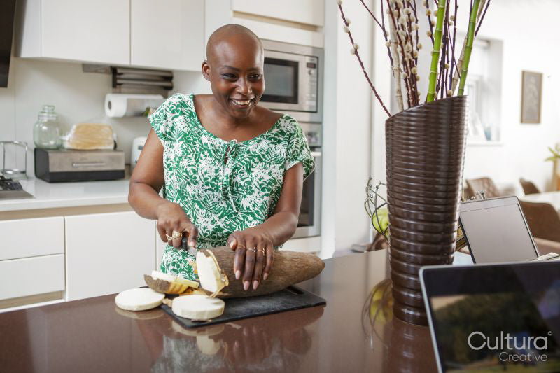 Woman slicing yam in kitchen