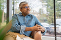 Smiling mature businessman sitting in chair in office