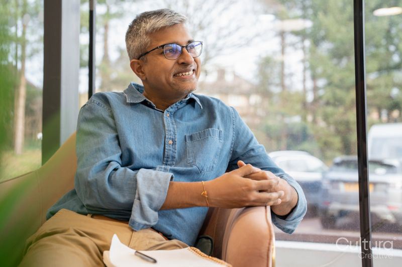 Smiling mature businessman sitting in chair in office