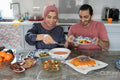 Mid adult couple eating meal at home