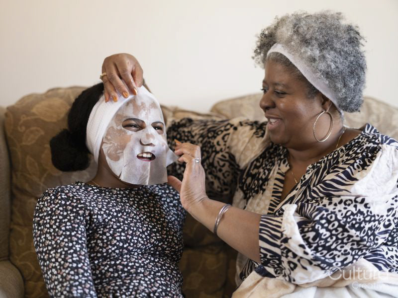 Mother and daughter applying face mask at home
