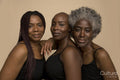 Studio portrait of three smiling women in black tops