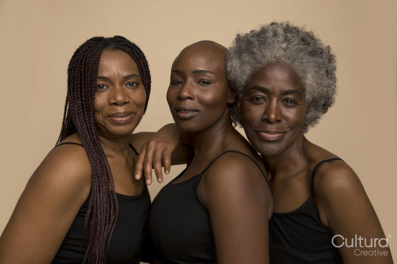 Studio portrait of three smiling women in black tops