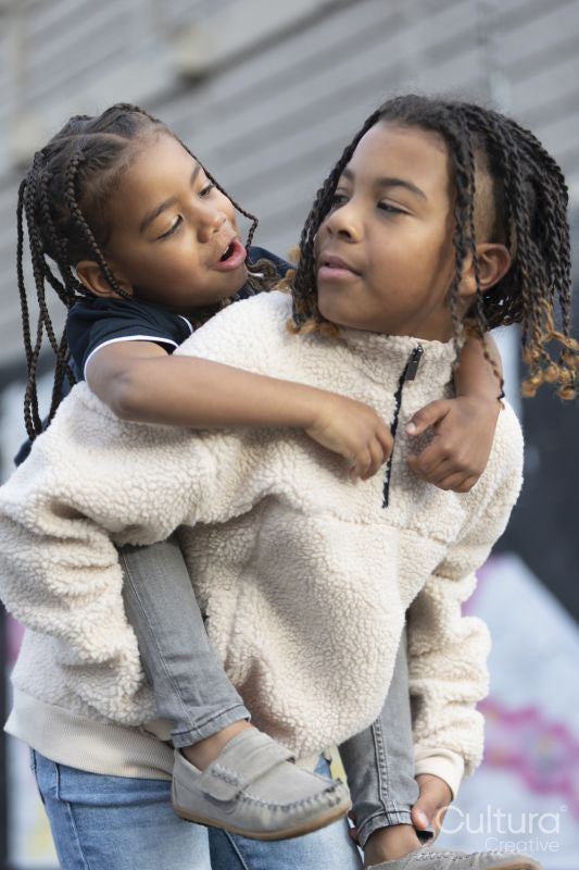 Portrait of boy giving piggyback ride to younger brother
