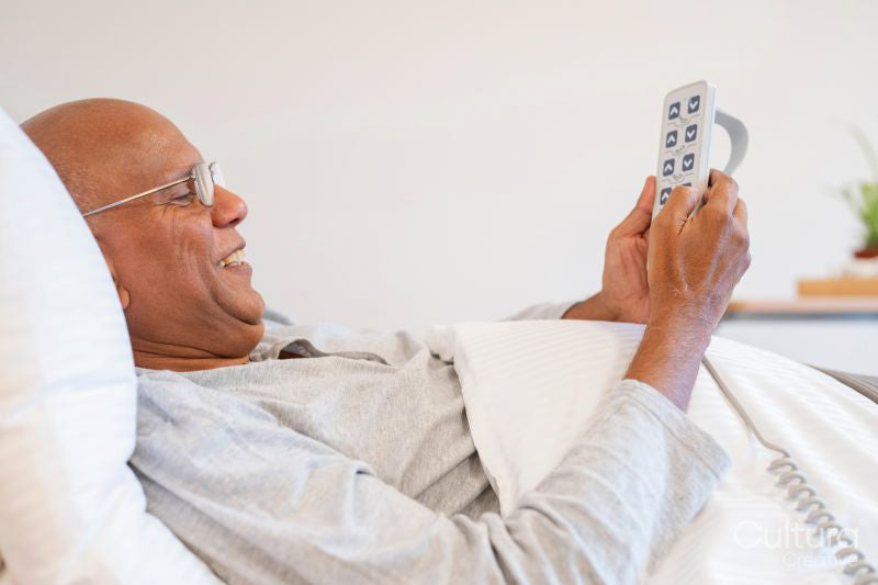 Senior man lying in adjustable bed in room at nursing home