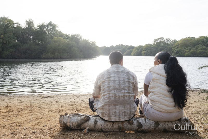 Rear view of couple sitting on lakeshore