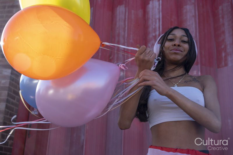 South Yorkshire, Portrait of smiling woman with headphones and balloons