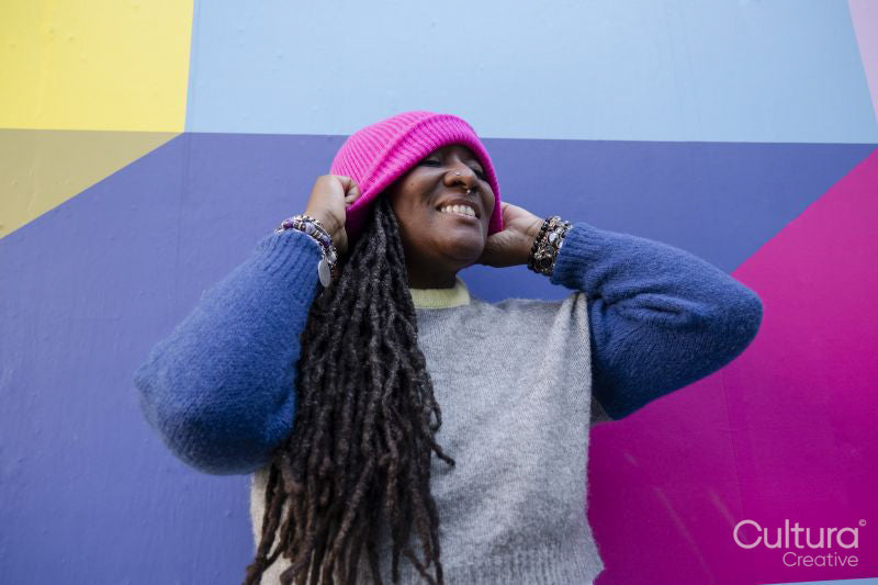 Portrait of beautiful woman putting on pink cap