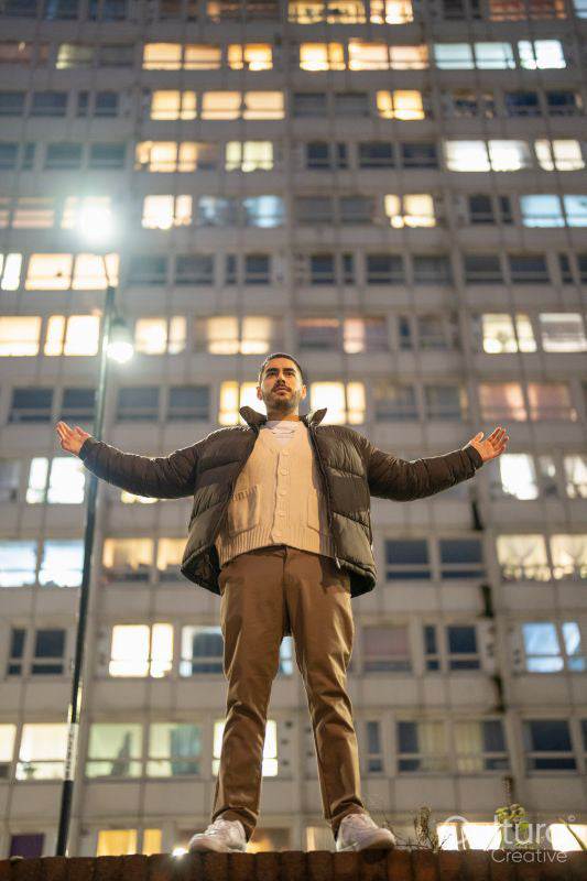 Young man standing in front of block of flats