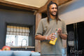 Man with dreads holding bottle of orange juice