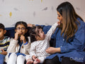Mother with children sitting on sofa and eating snacks