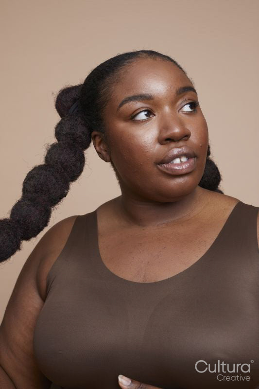 Studio shot of smiling young woman with braided hair