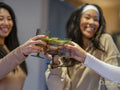 Female friends making celebratory toast at home