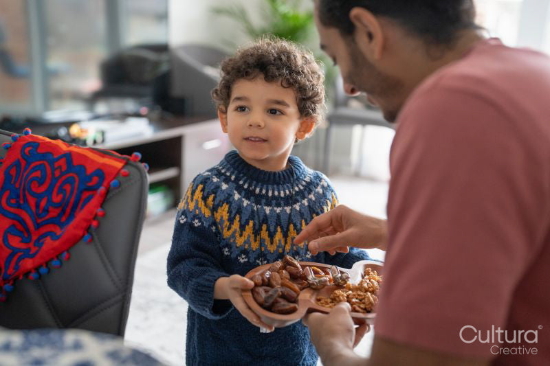 Father and son eating dates at home