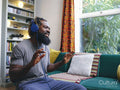 Man sitting on sofa,listening to music on headphones