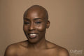 Studio portrait of smiling woman with shaved head