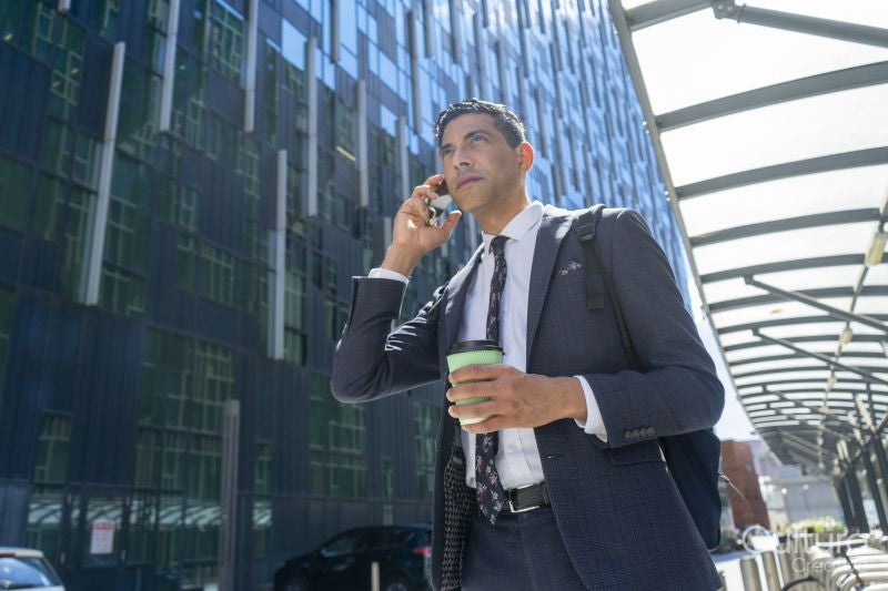 Businessman walking in business district and talking on phone