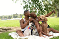 Louisiana, Smiling couple with dogs taking selfie on lawn in park